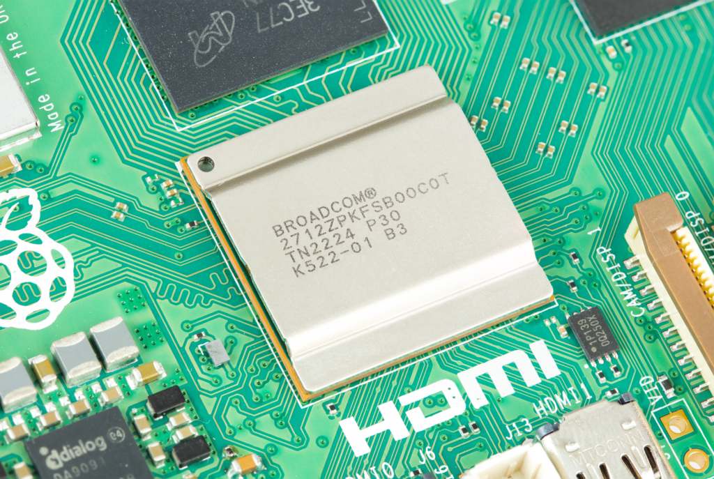 Close-up photo of part of the Raspberry Pi 5 board, centring the metal shield over the BCM2712 chip, with laser etching identifying the chip.